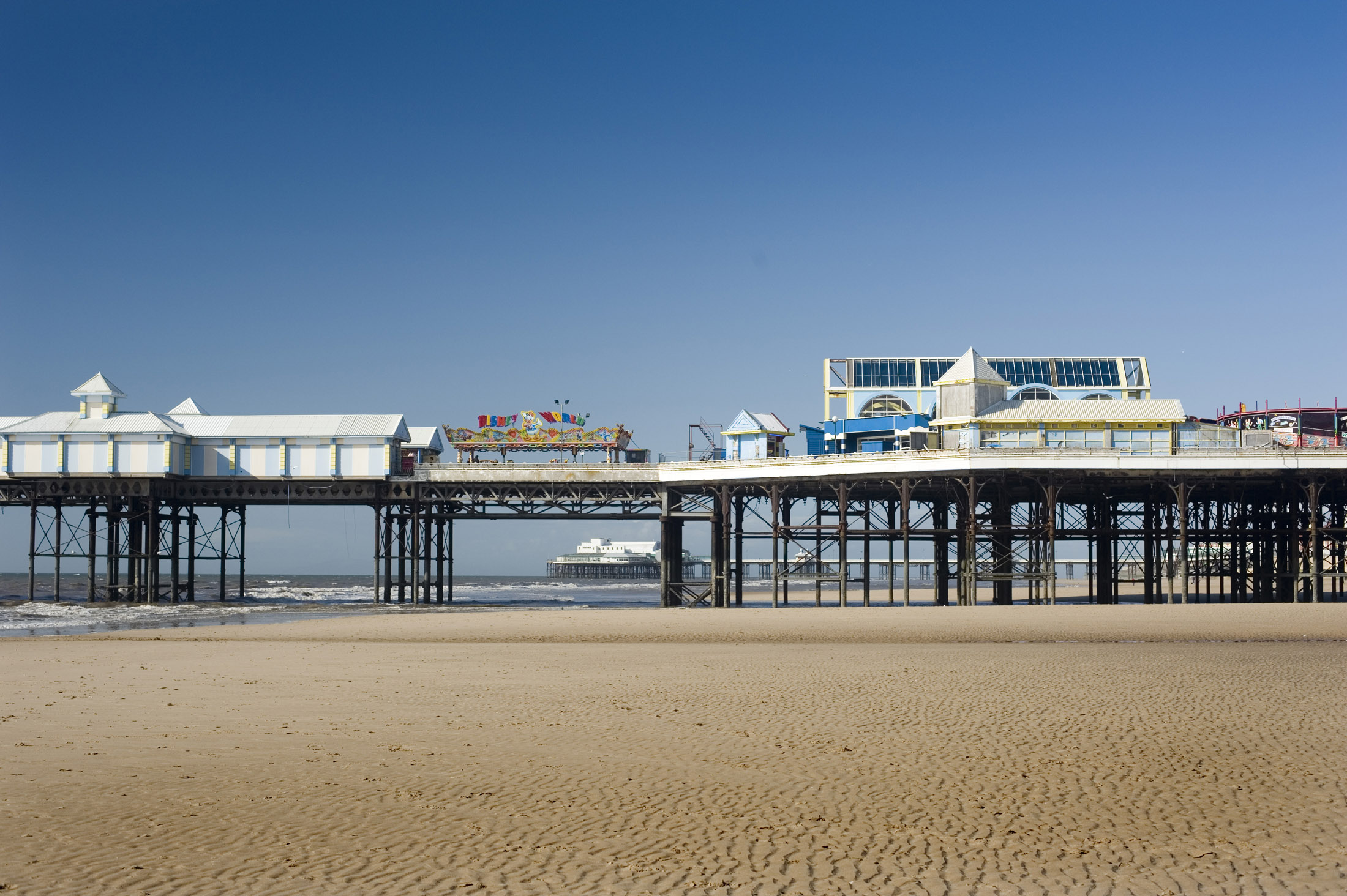 an image of a view of blackpools central pier, the north pier can be seen in the distance