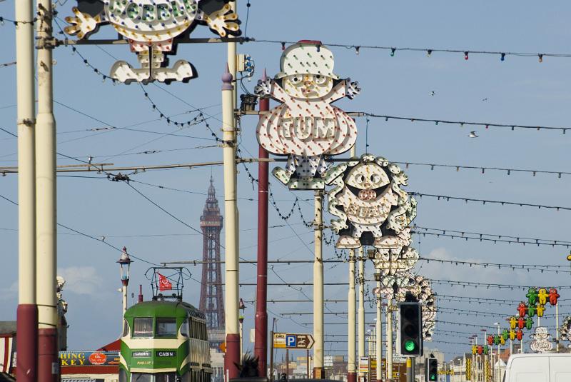 a view down blackpool promenade, illuminations, a tram and blackpool tower