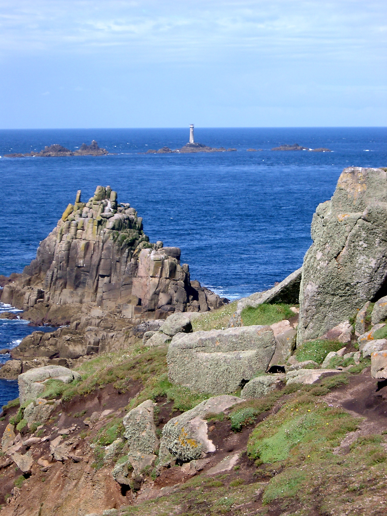 an image of coastal outcrops and the longships lighthouse at lands end cornwall