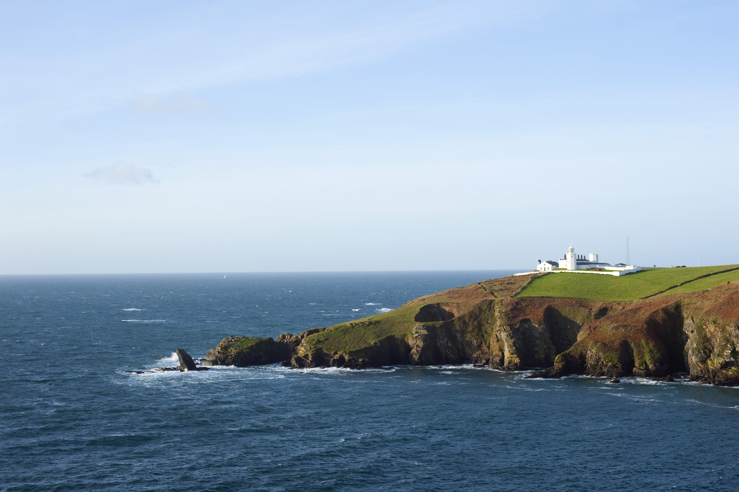an image of Lighthouse guides shipping around the rocks on england most southerly point