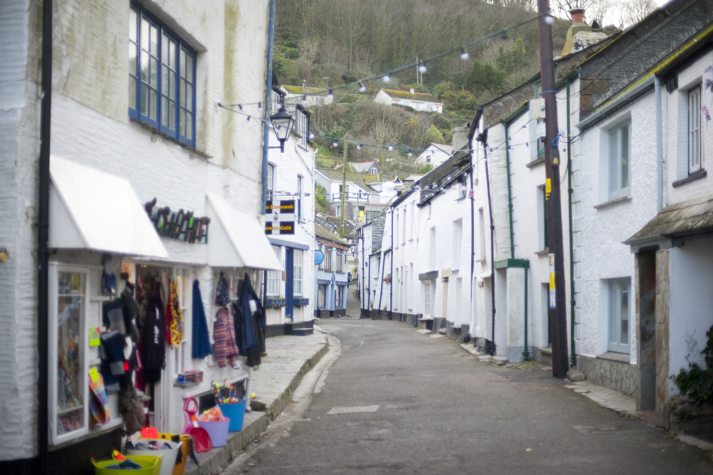 an image of narrow street of white painted rustic built houses in polperro an unspoilt cornish fishing village