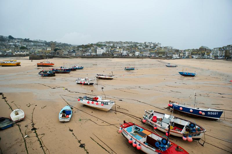fishing boats tied up in saint ives harbour at low tide