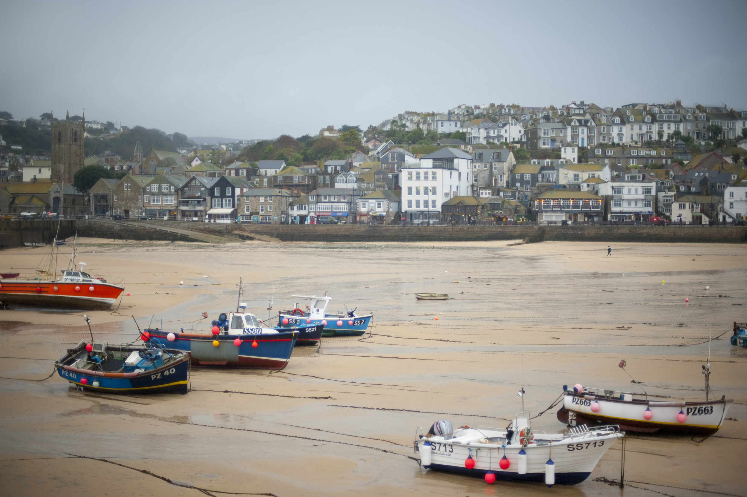 an image of fishing boats at low tide in the harbour at saint ives, cornwall