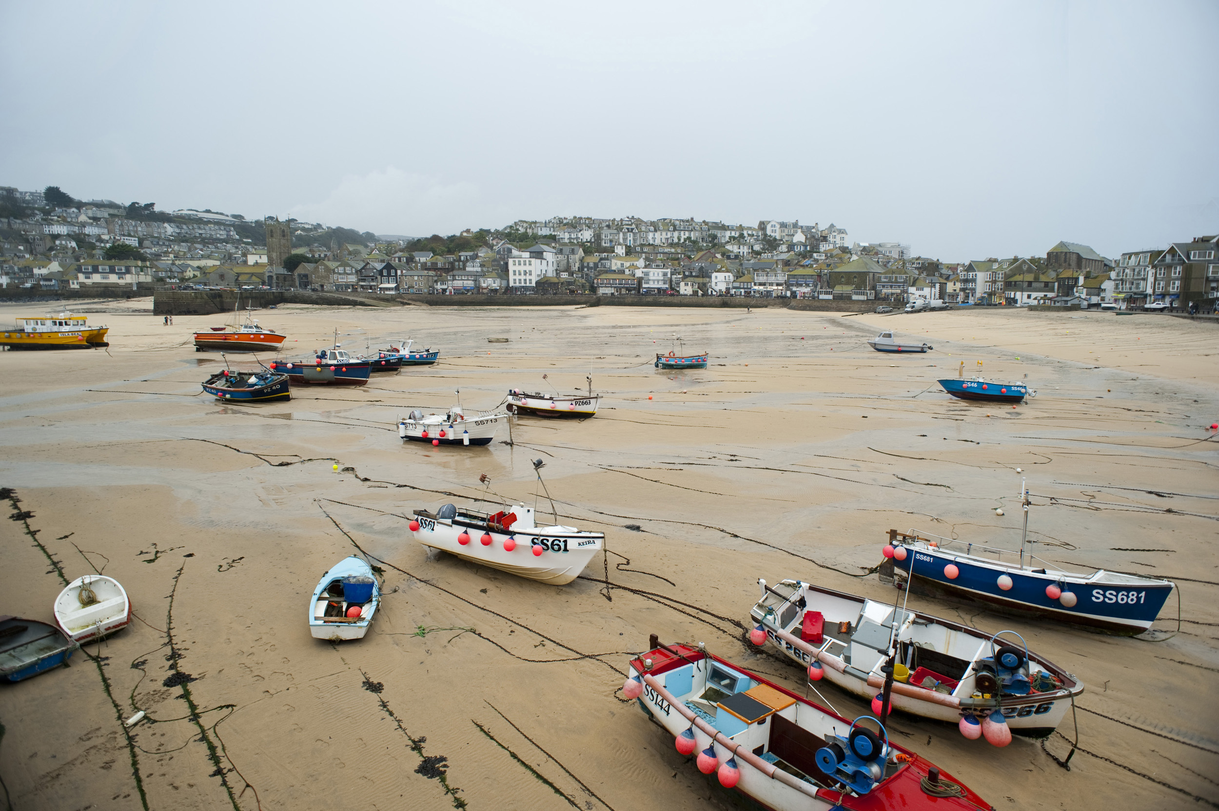 an image of fishing boats tied up in saint ives harbour at low tide
