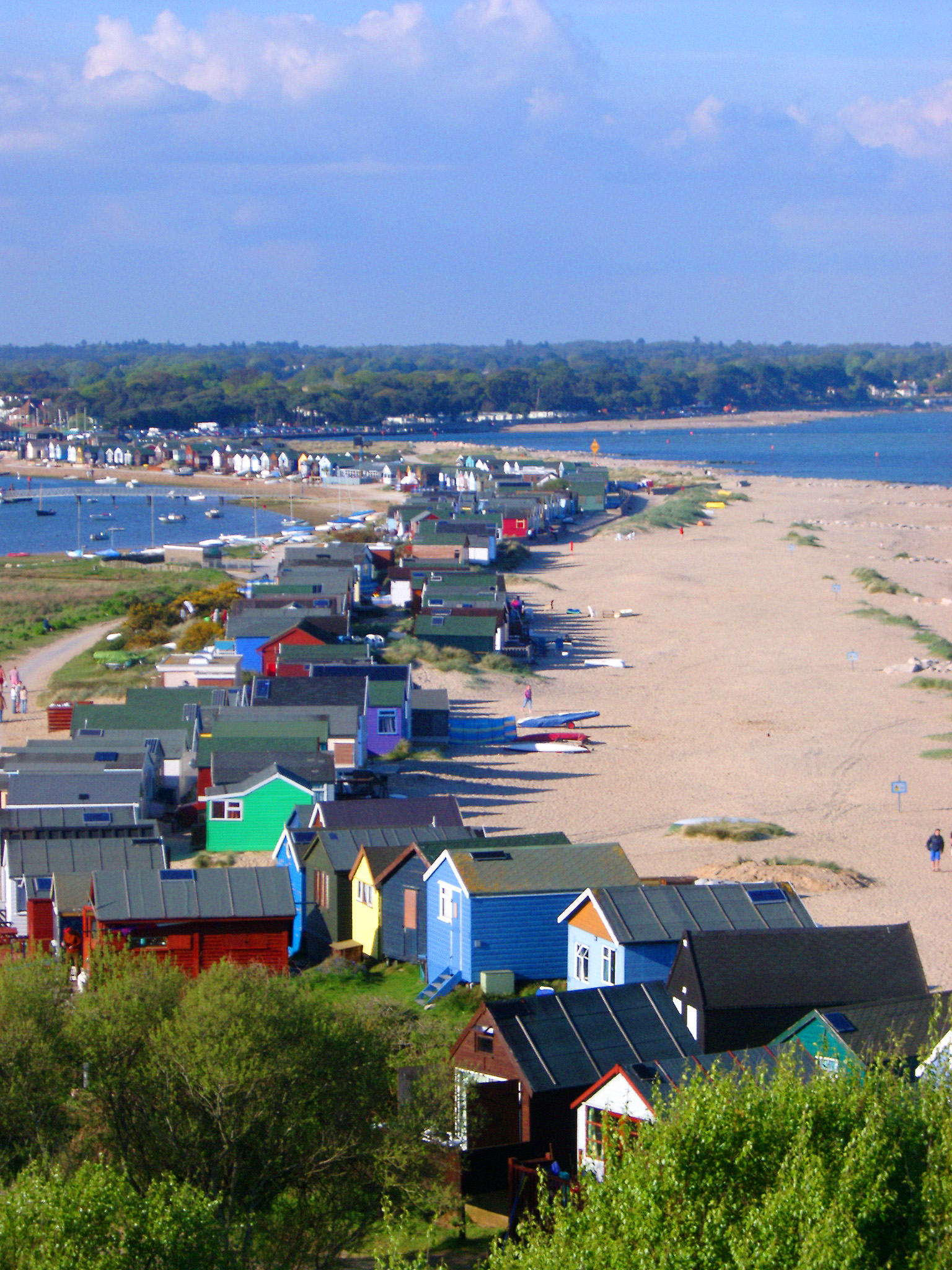 an image of beach huts on the edge of christchurch harbour, dorset, uk