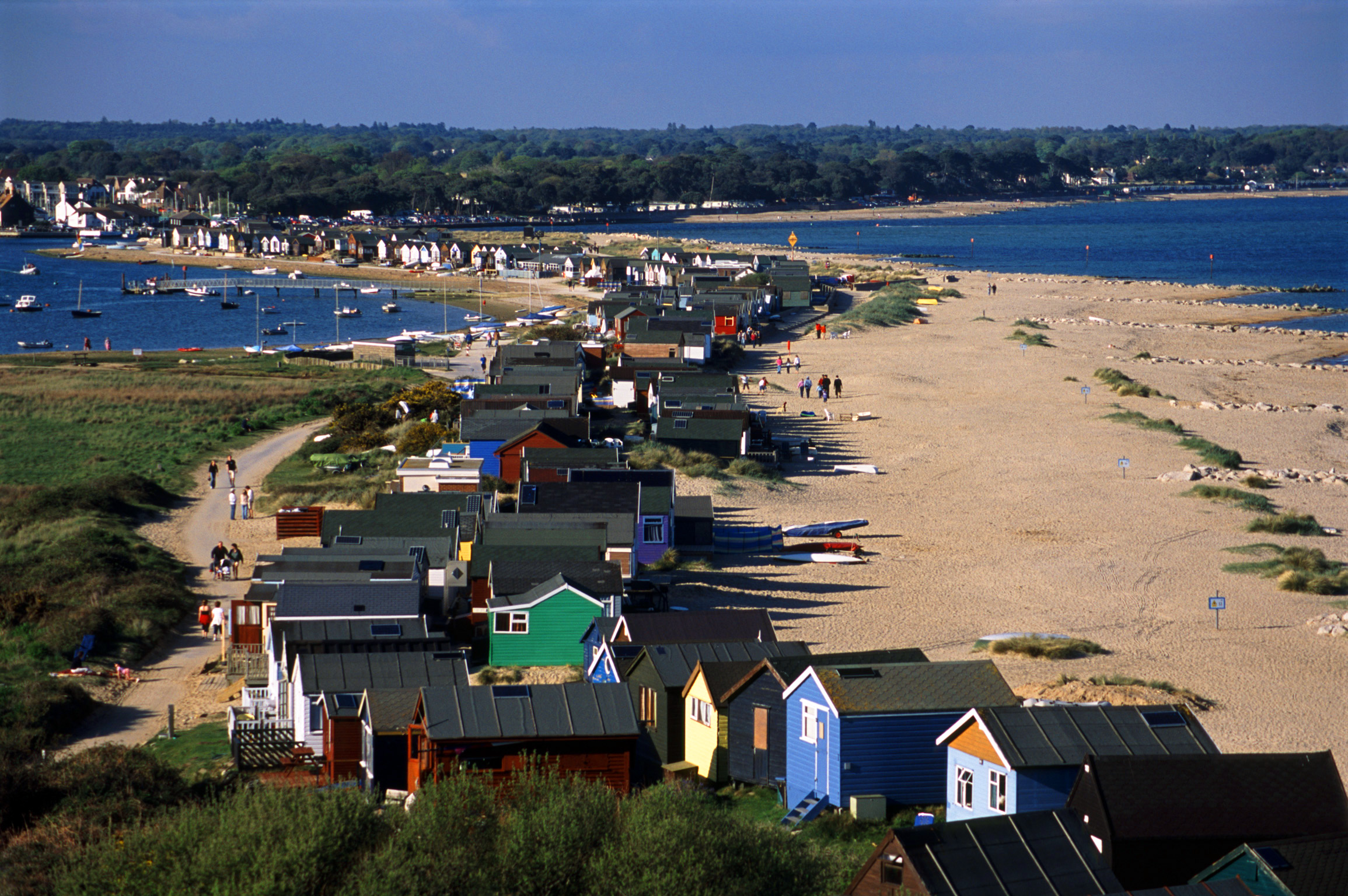 an image of line of beach huts on the mudeford sand spit, christchurch harbour, dorset
