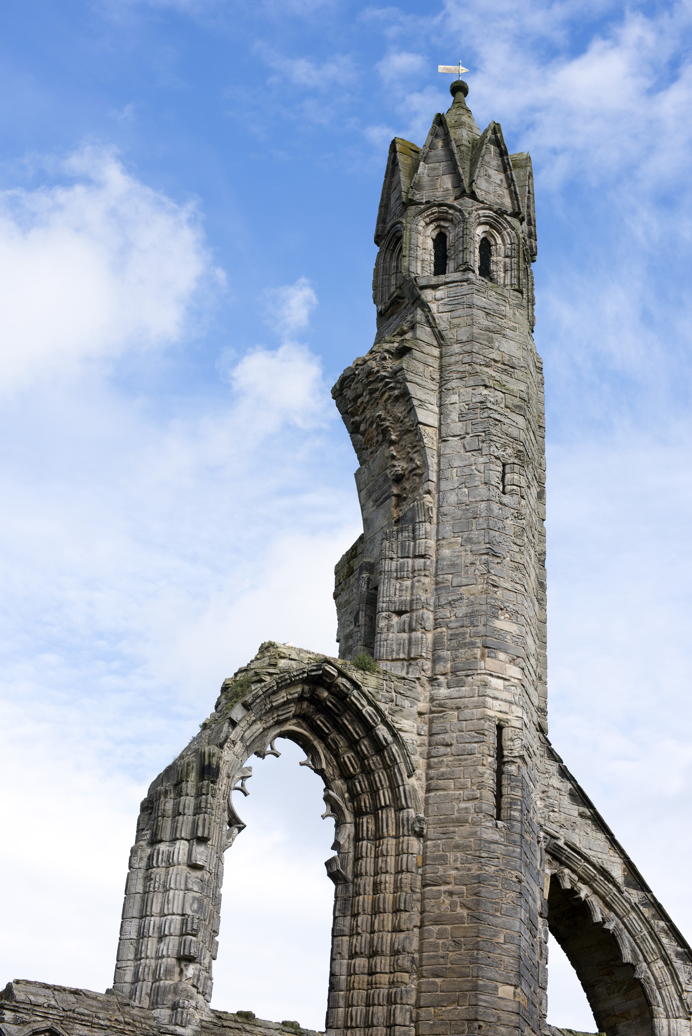 an image of Low angle view on old stone carved tower of Saint Andrews Cathedral under partly sunny sky