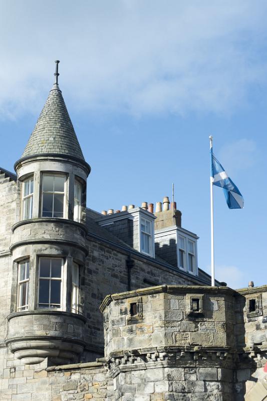 Lovely stone building at the west port, st andrews, with conical roofed tower and rookery with lone flag flying on white pole