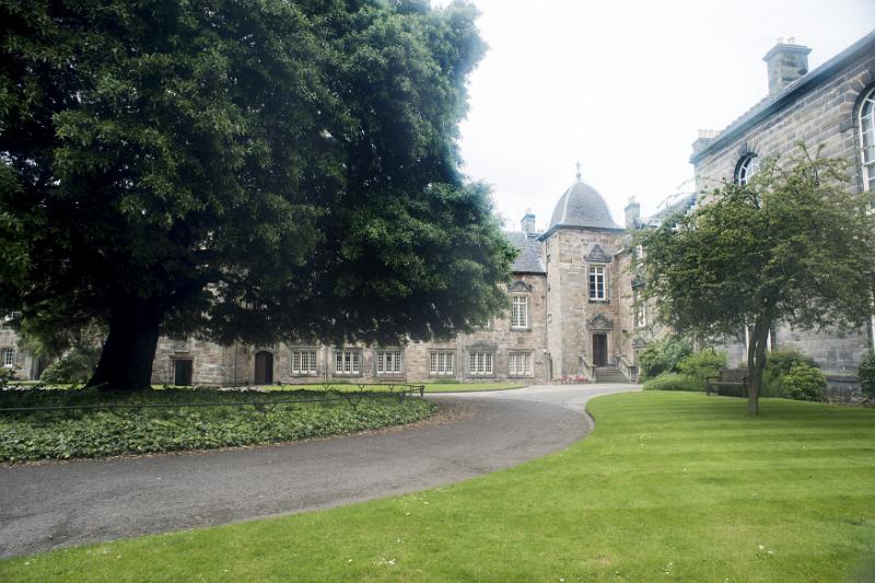Paved asphalt winding walkway leading to little corner section of University of Saint Andrews in Scotland