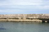 Seawall on the harbour or marina, Anstruther, Scotland with sheltered water in the foreground for safe mooring