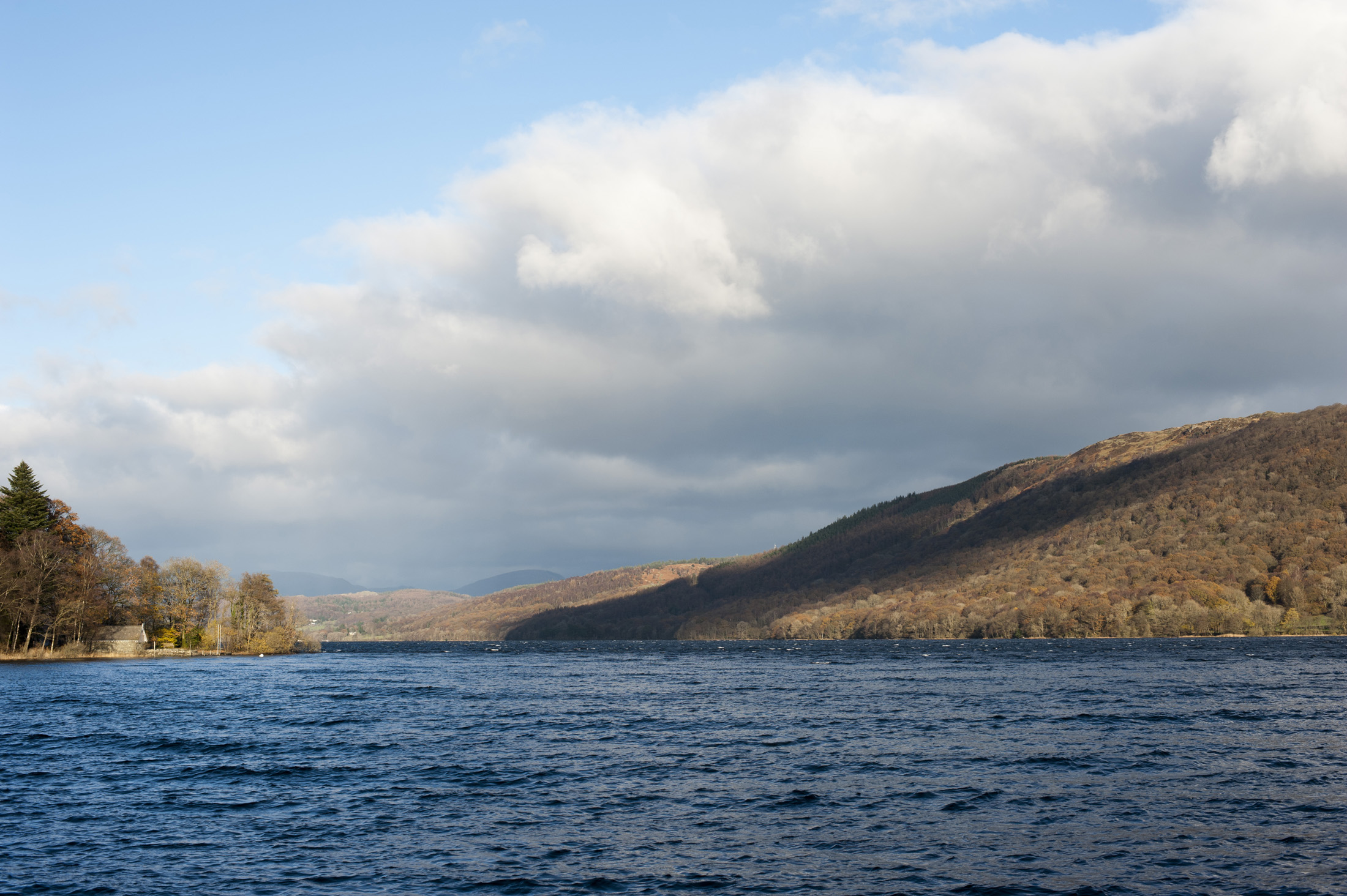 an image of Scenic landscape view of the calm blue water of Lake Coniston in the Lake District , Cumbria