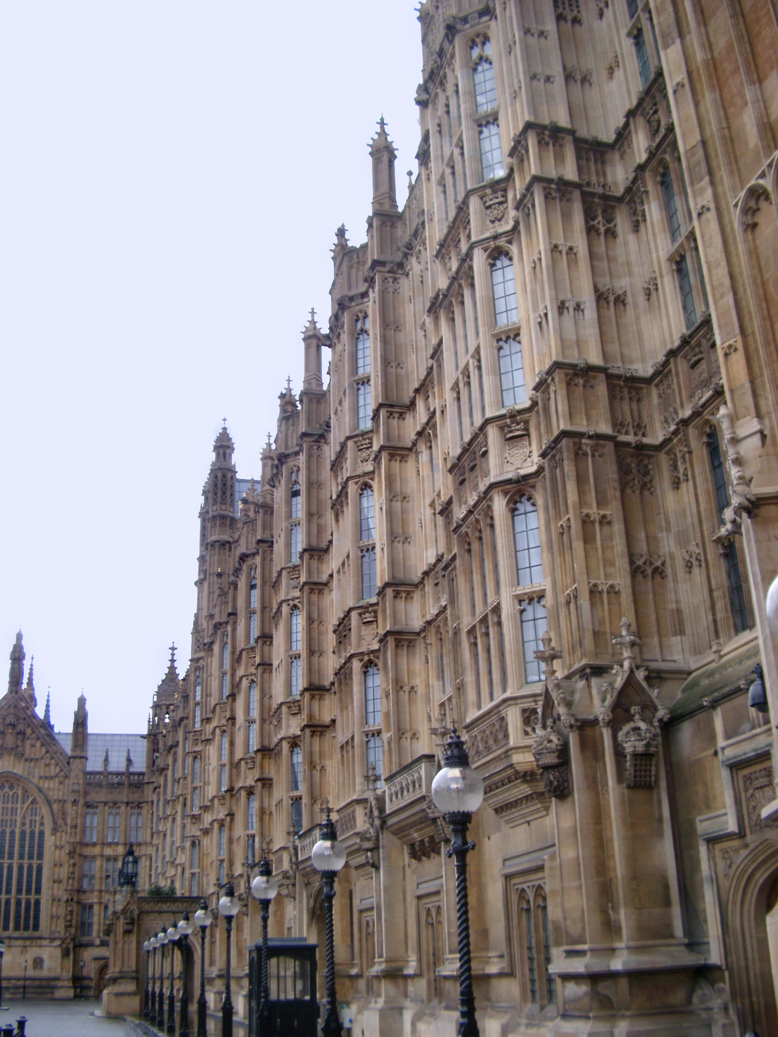 an image of View down the length of the Gothic revival stone carved facade of the historical Palace of Westminster, London