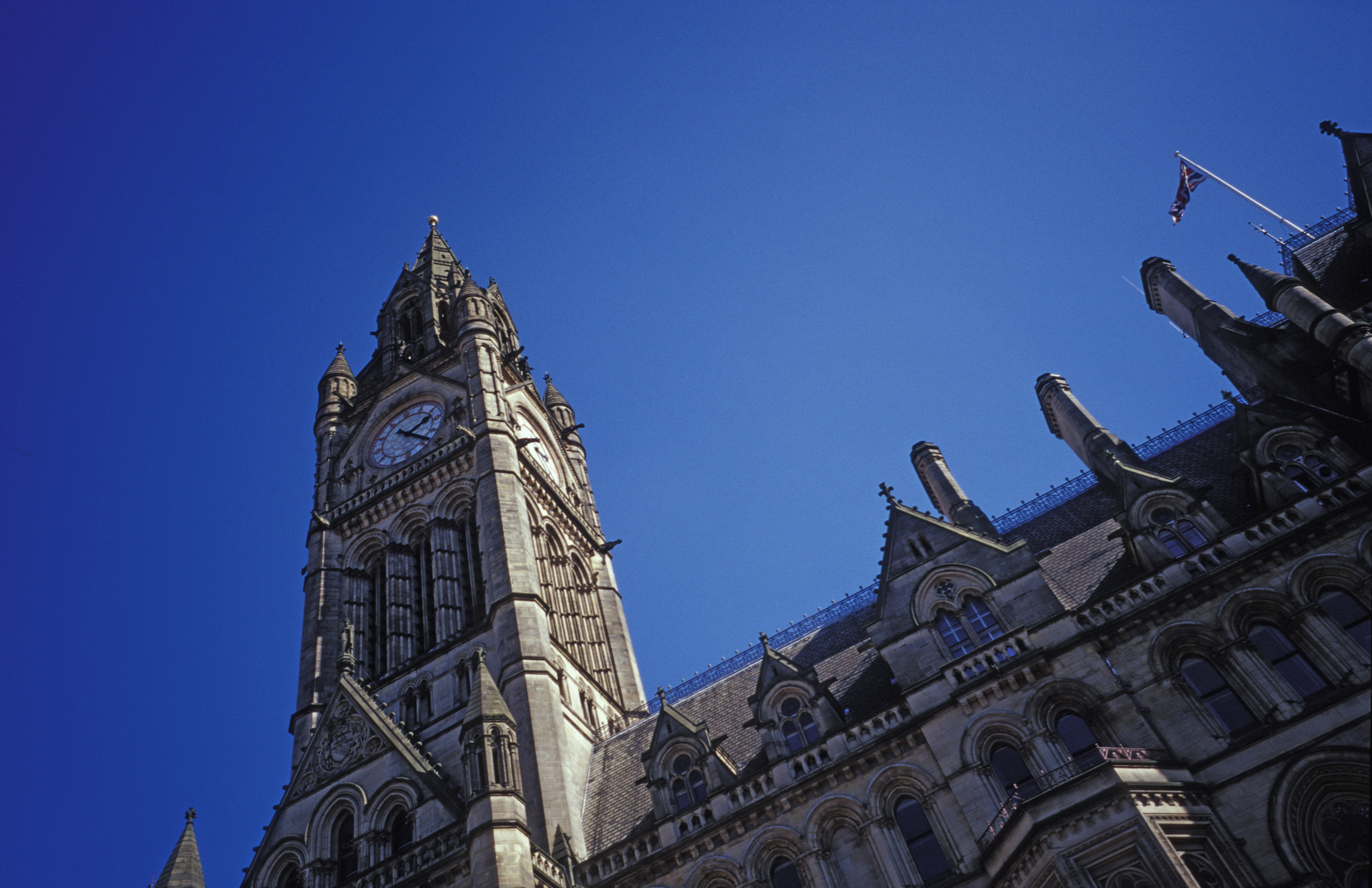 an image of low angle view looking up at the clock tower of manchester town hall