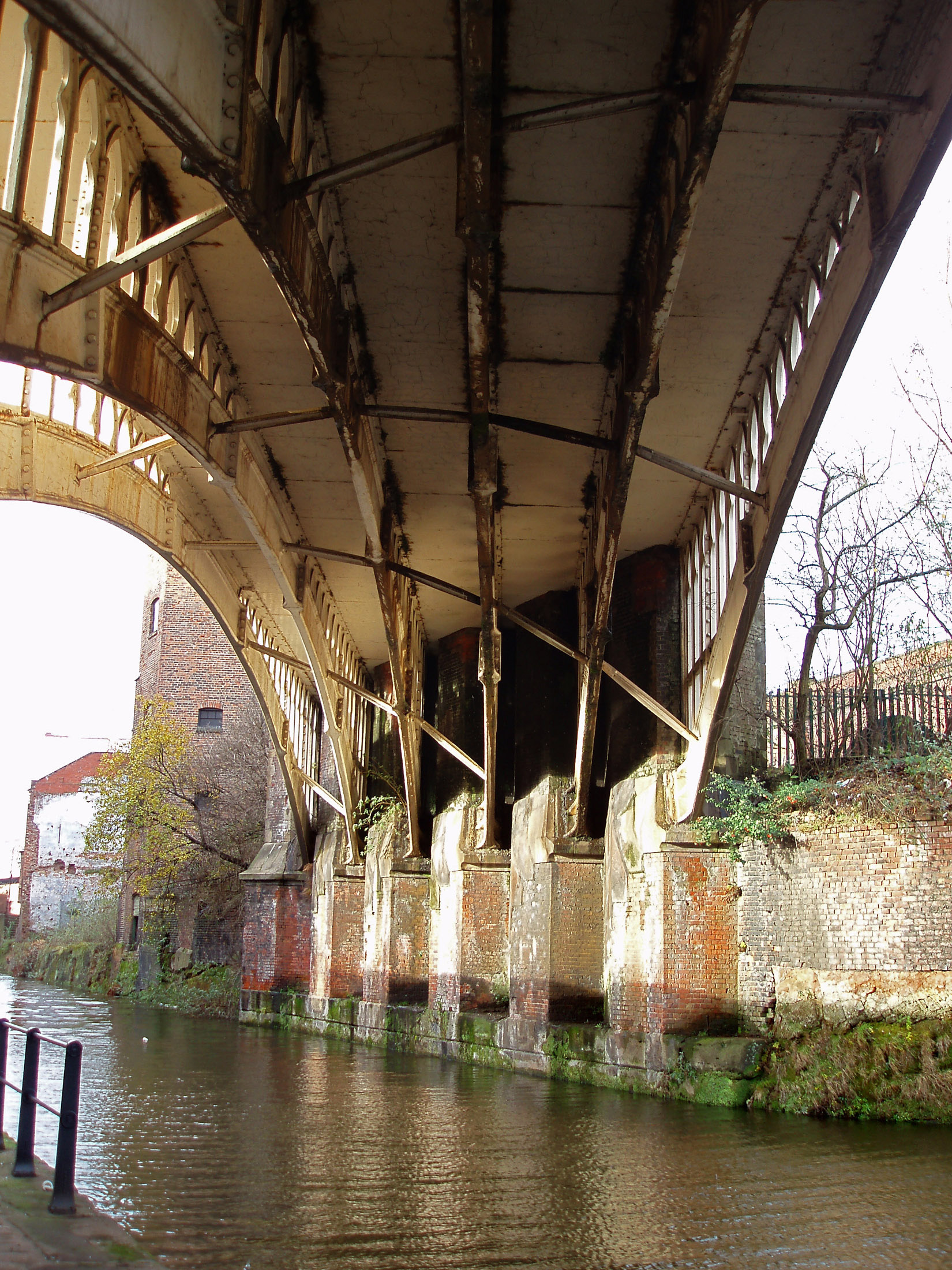 an image of Old iron railway bridge crossing an industrial canal in Castlefield, Manchester, an innercity conservancy area to the Industrial Revolution