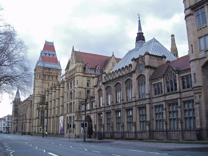 View of the street and exterior facade in the Gothic revival style of architecture of the Manchester University building