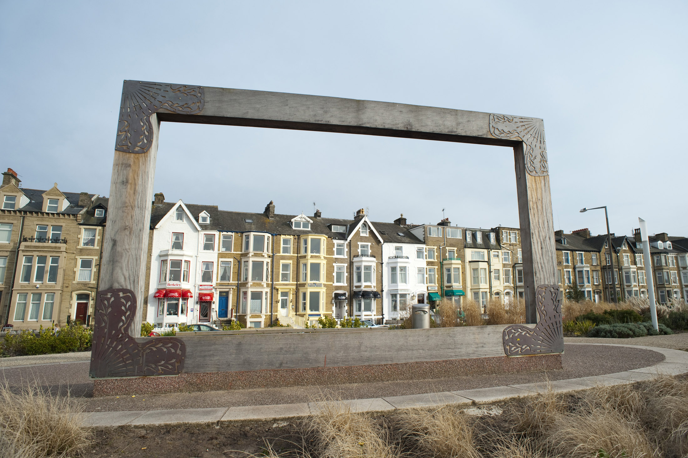 an image of a large wooden picture frame at the west end gardens in morecambe, when viewed from the opposite side allows visitors to frame a bleak vista of morecambe sands