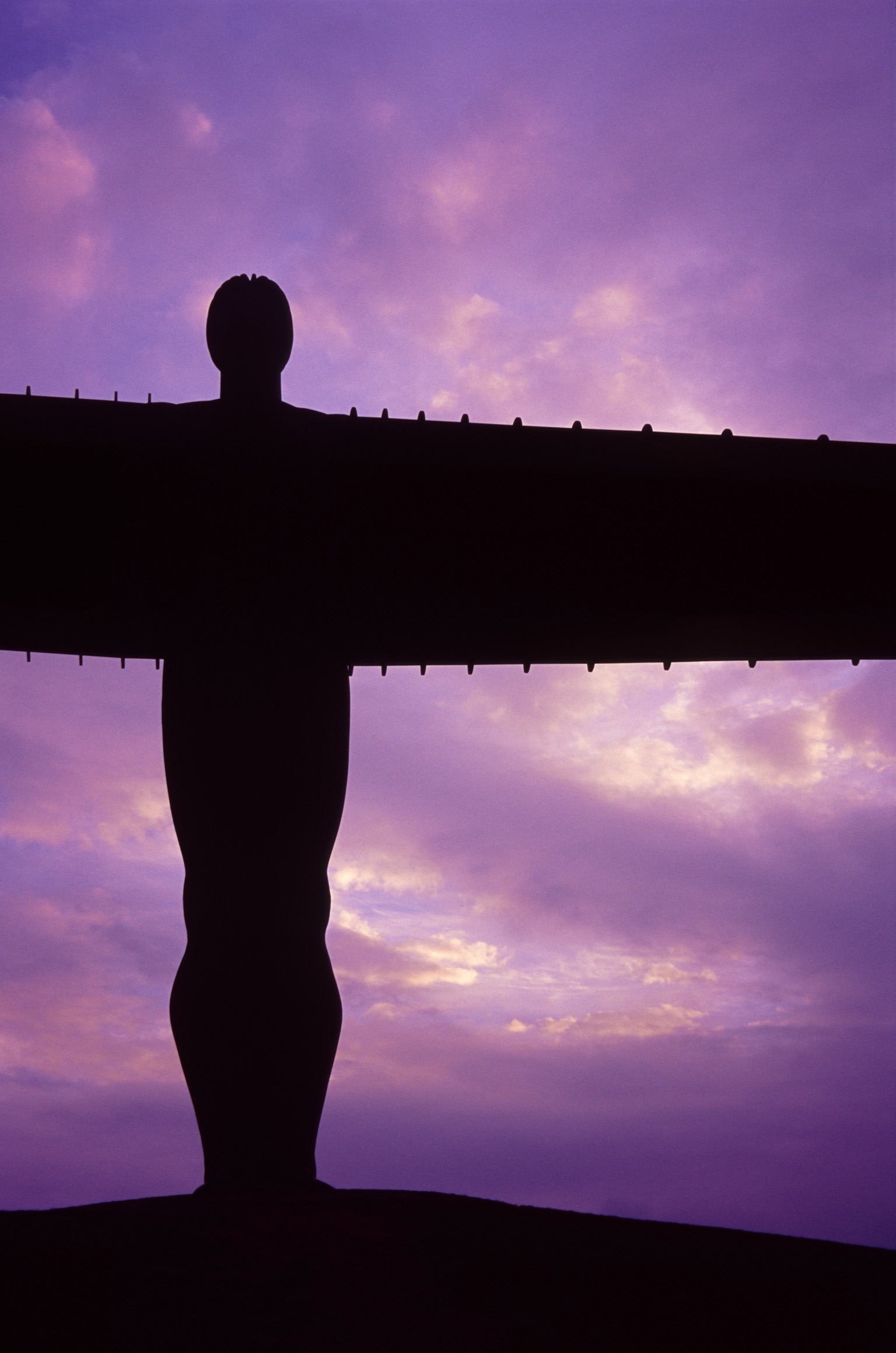 an image of Close up detail of the body of the Angel of the North silhouetted against a vivid purple sunset sky, Gateshead, Newcastle
