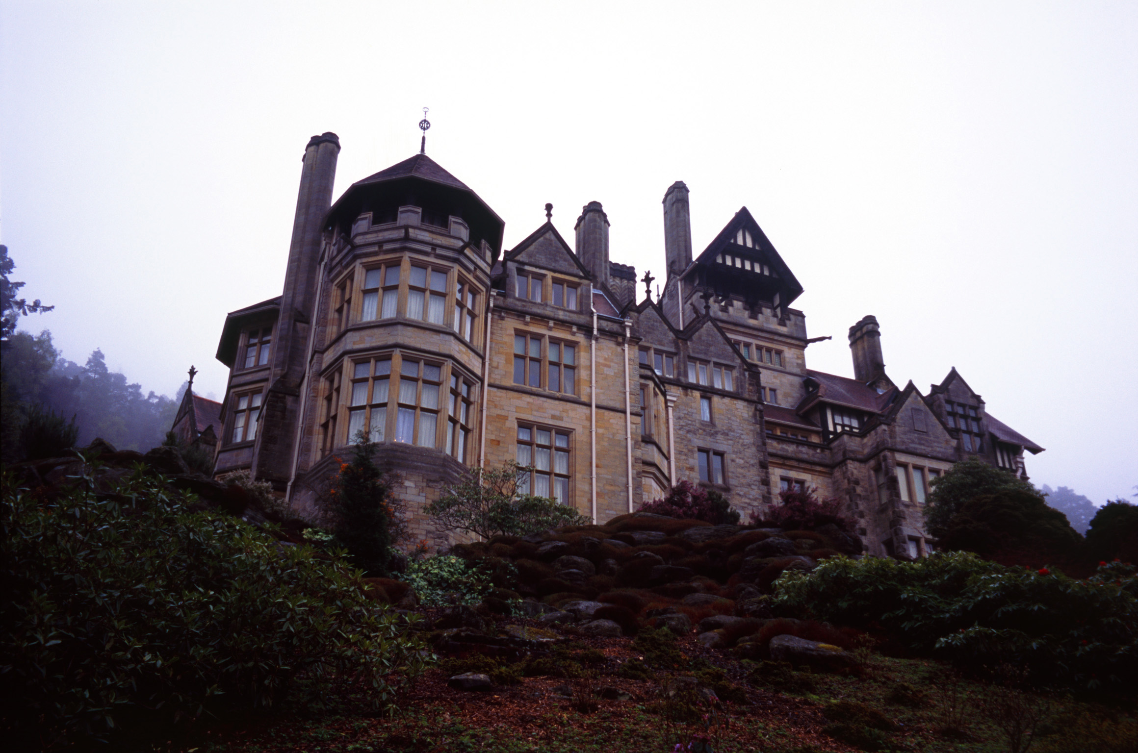 an image of View on the skyline of the large stone facade of Cragside stately home, the first house to have electricity