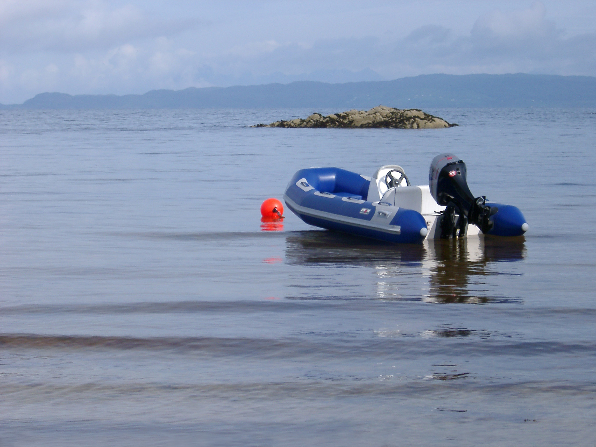 an image of Small Blue Motorboat for Leisure Activity Resting on the Beautiful Sea at Scotland