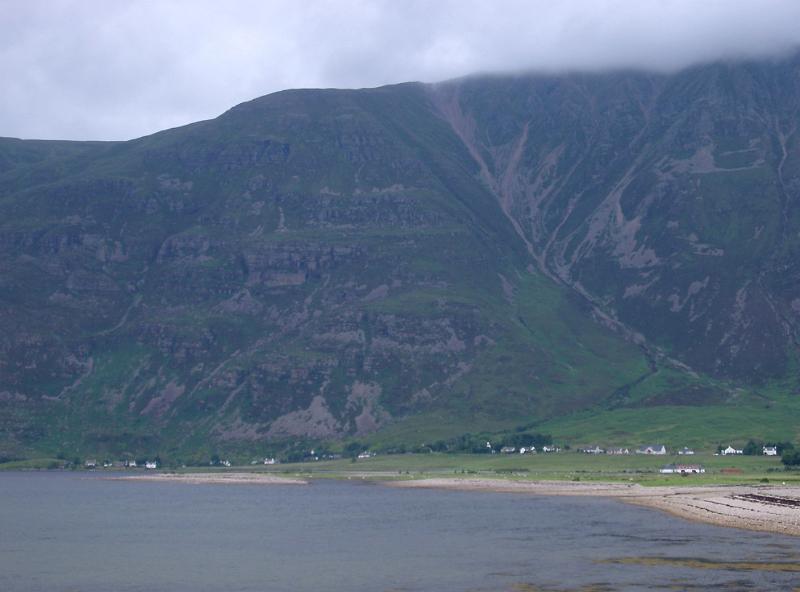 Beach and small settlement on the shores of a loch in the Scottish highlands pictured on a cold misty day