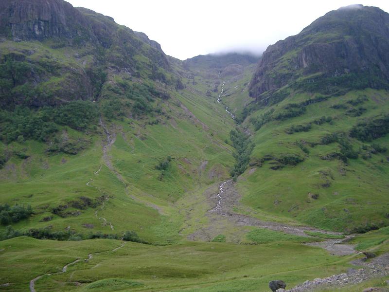 Rugged Highland mountains with a waterfall tumbling down the mountainside to the valley below in Scotland