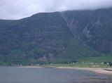 Beach and small settlement on the shores of a loch in the Scottish highlands pictured on a cold misty day