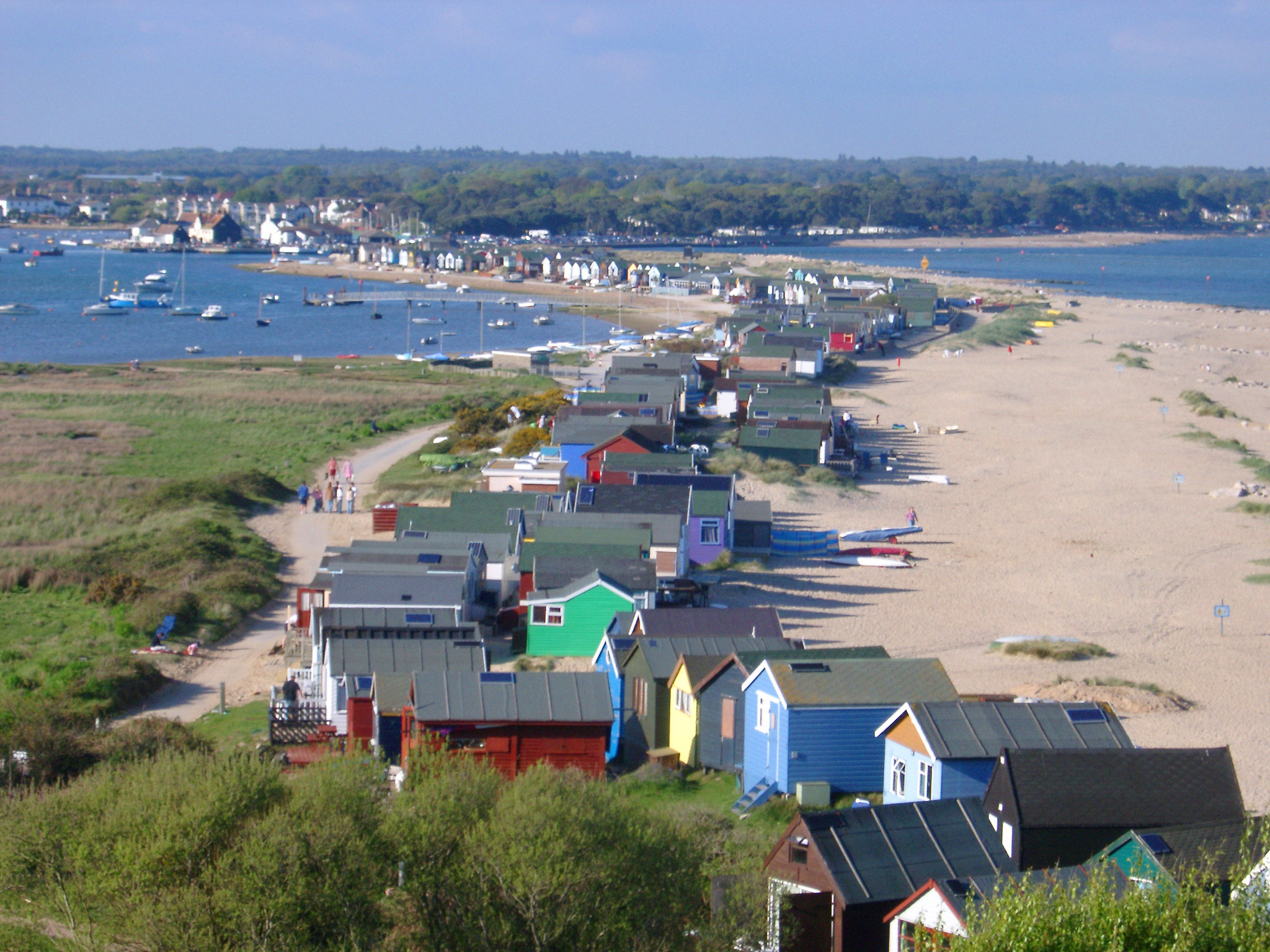 an image of Row of colorful beach huts or cabins for vacations and getaways lining the Dorset seashore, high angle landscape view