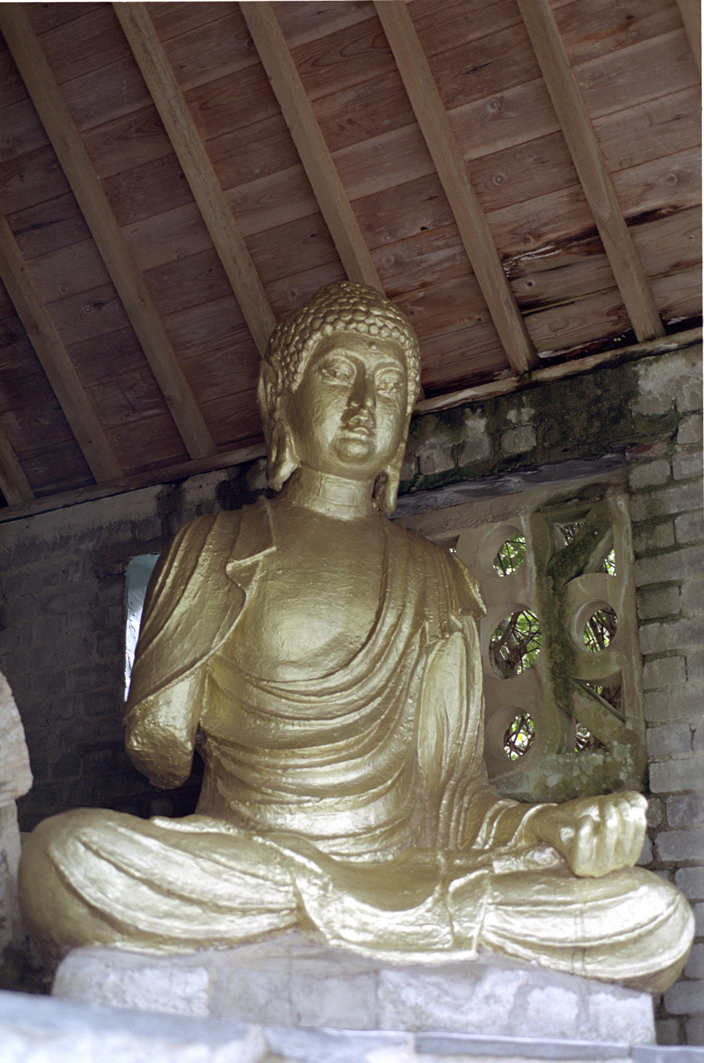 an image of Seated Gold Buddha, a Gift to the Village of Portmeirion, a Popular Tourist Village in Gwynedd, North Wales
