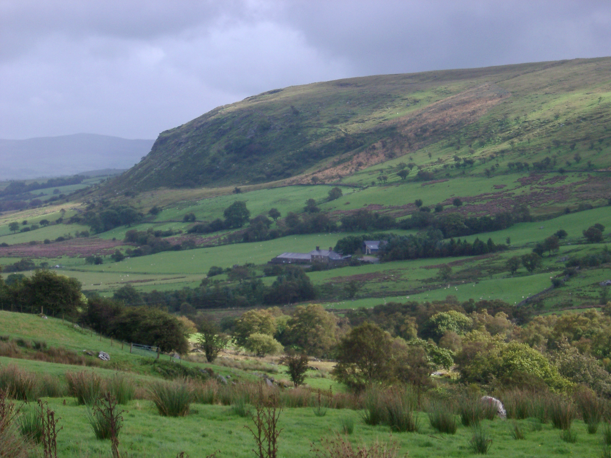 an image of Lush green valley and hill in the Welsh countryside on a wet cloudy day