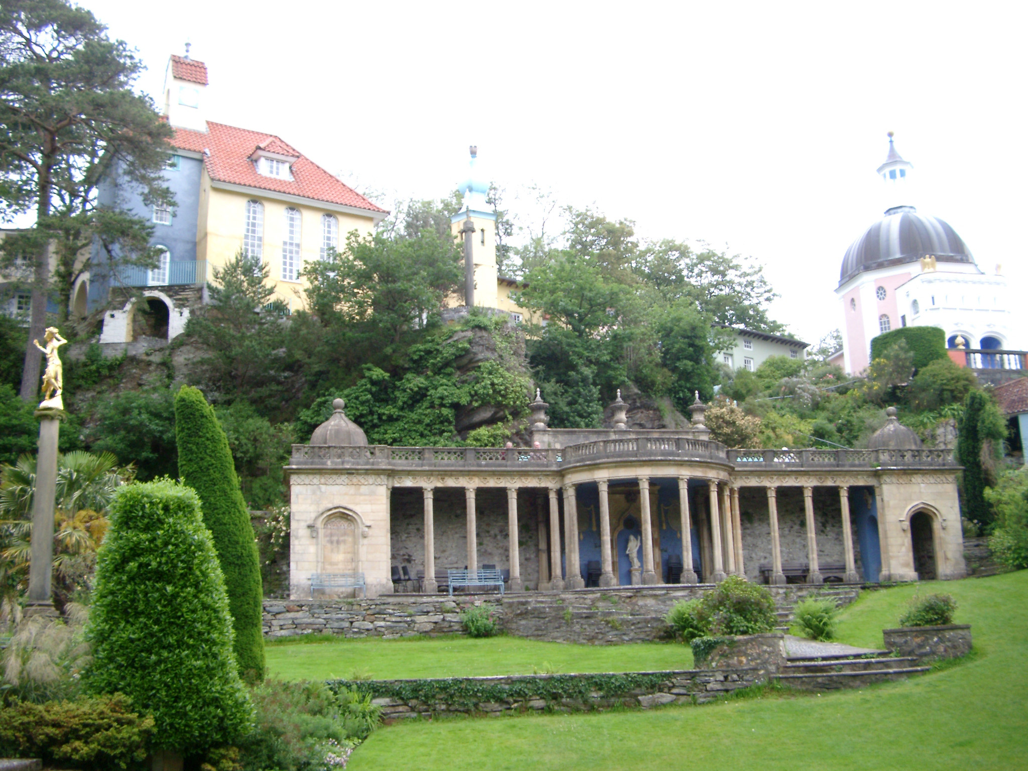 an image of Portmeirion architecture, Wales, modeled on an Italian village , showing a building with a colonnade portico overlooking landscaped gardens in this popular tourist resort
