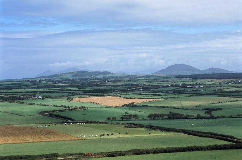 Patchwork of green agricultural fields on the Llyn peninsula with a scenic landscape view across to distant mountains