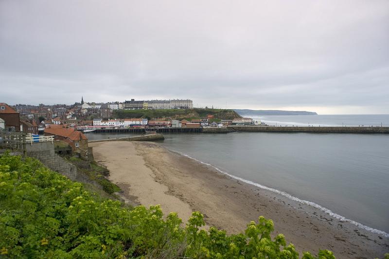 a view of whitby and west cliff on a stormy day