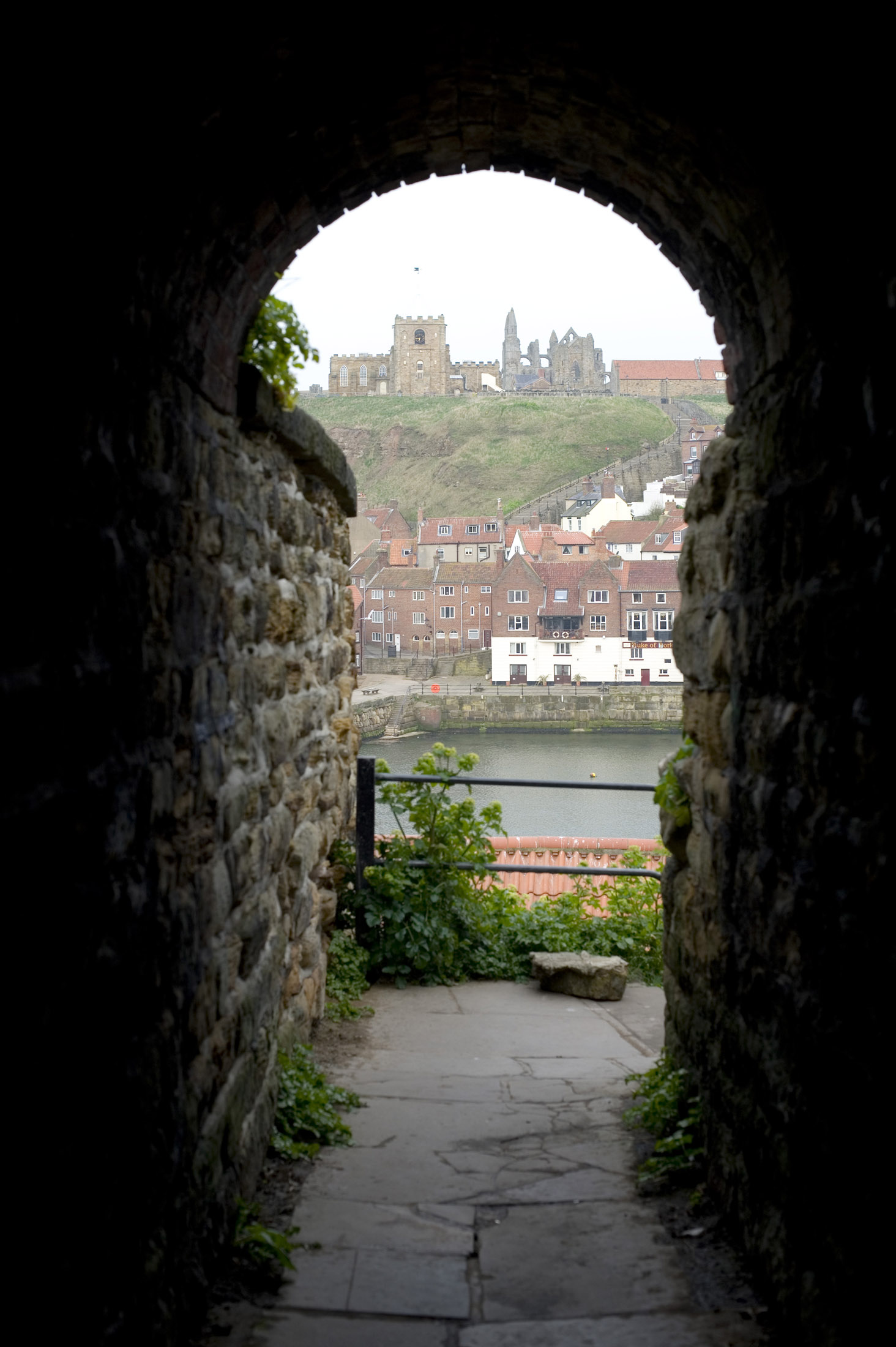 an image of a narrow stone passage leads through to a flight of steps into the town from the west cliff