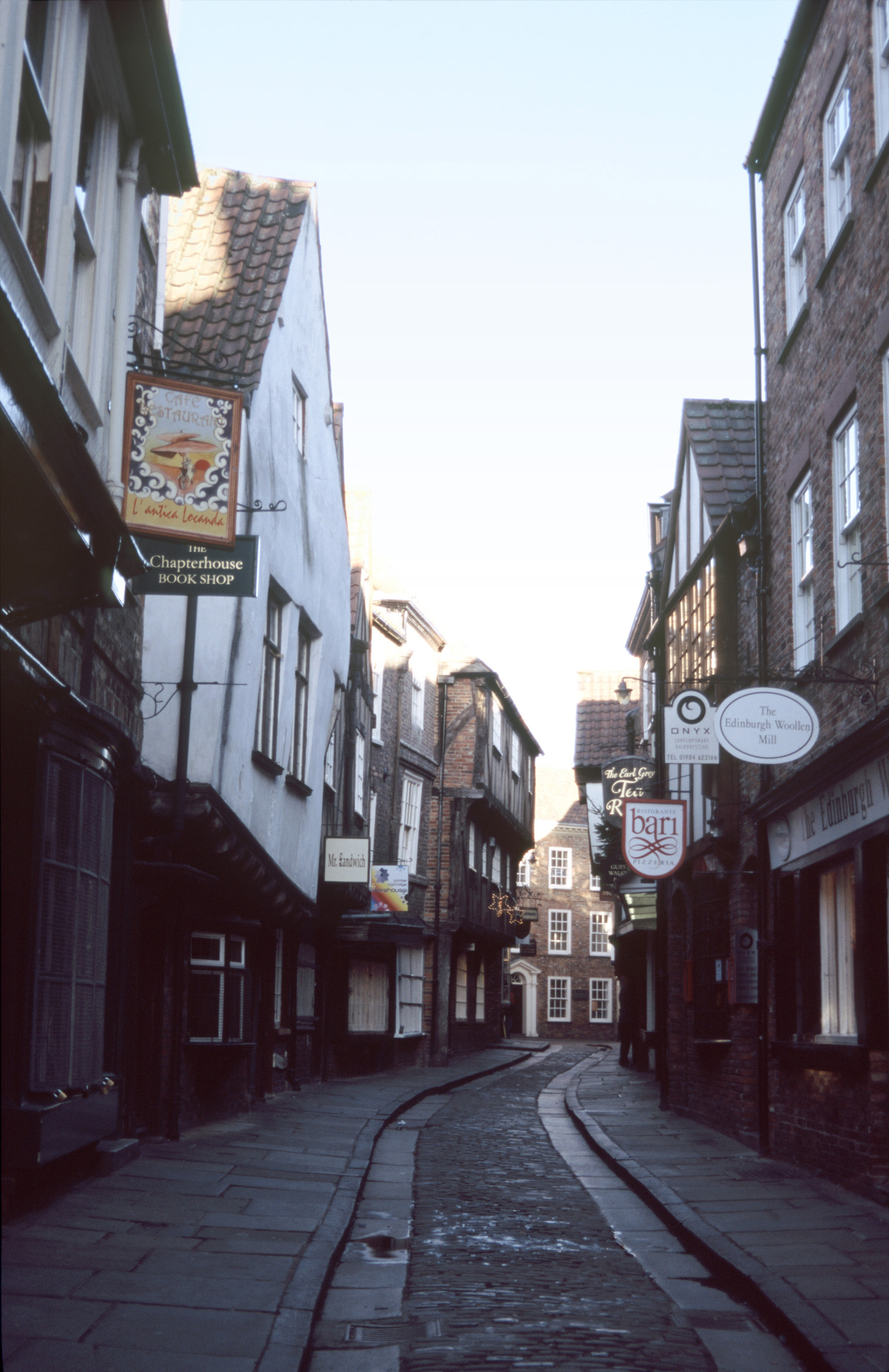 an image of The Shambles, York, a tourist trap with quaint shops lining a narrow cobbled street in a picturesque view