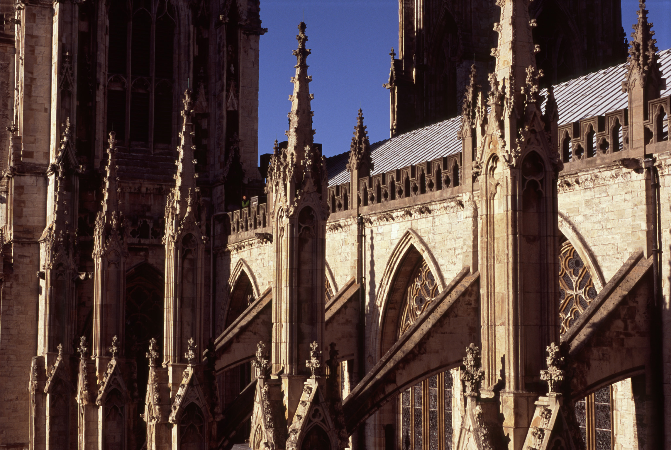 an image of Architectural detail of a minster showing the flying buttresses on the exterior of the building each ending in a small spire