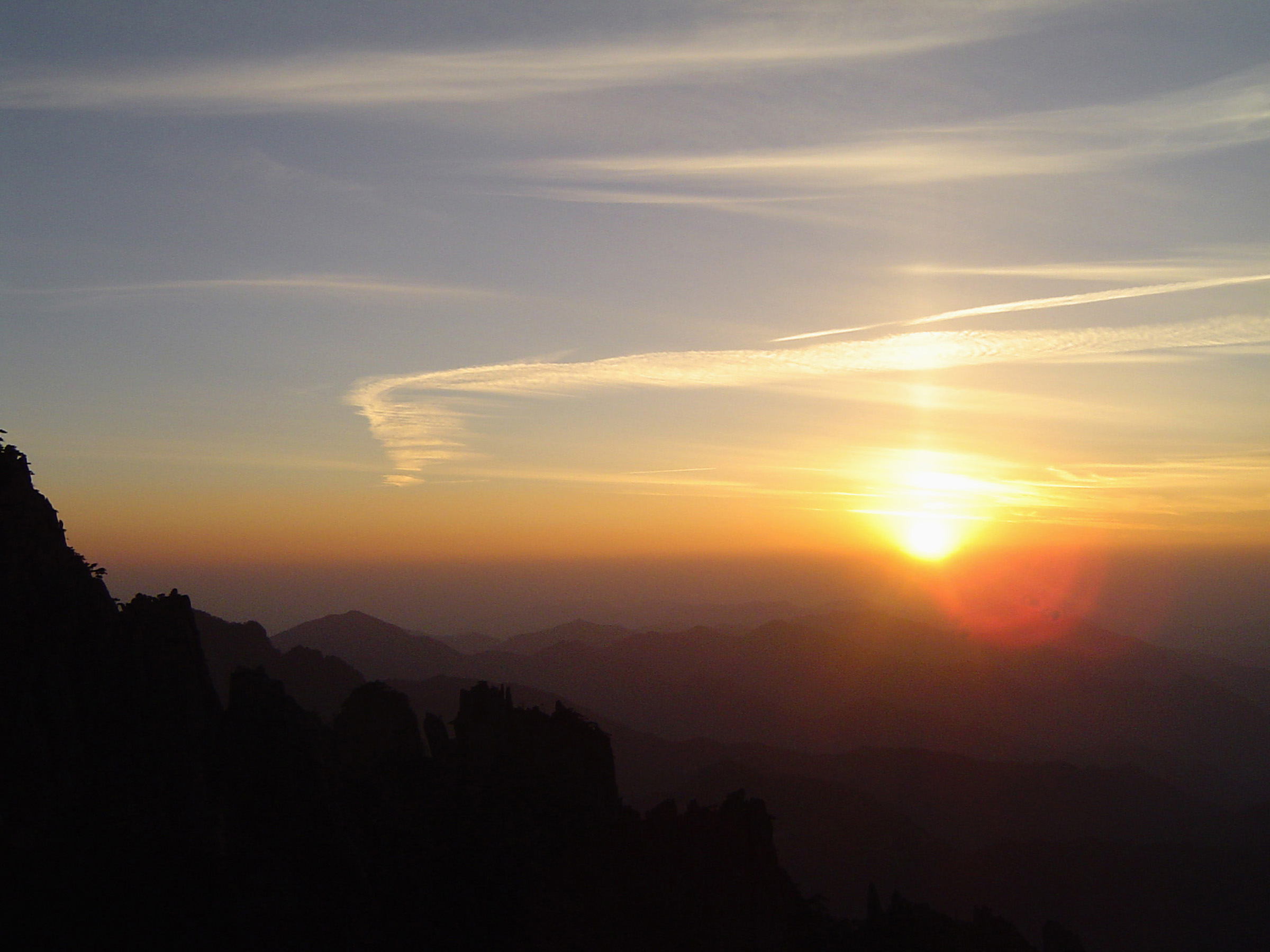 an image of Panoramic scenic landscape with high mountain range in the warmth and light of the sun, at twilight