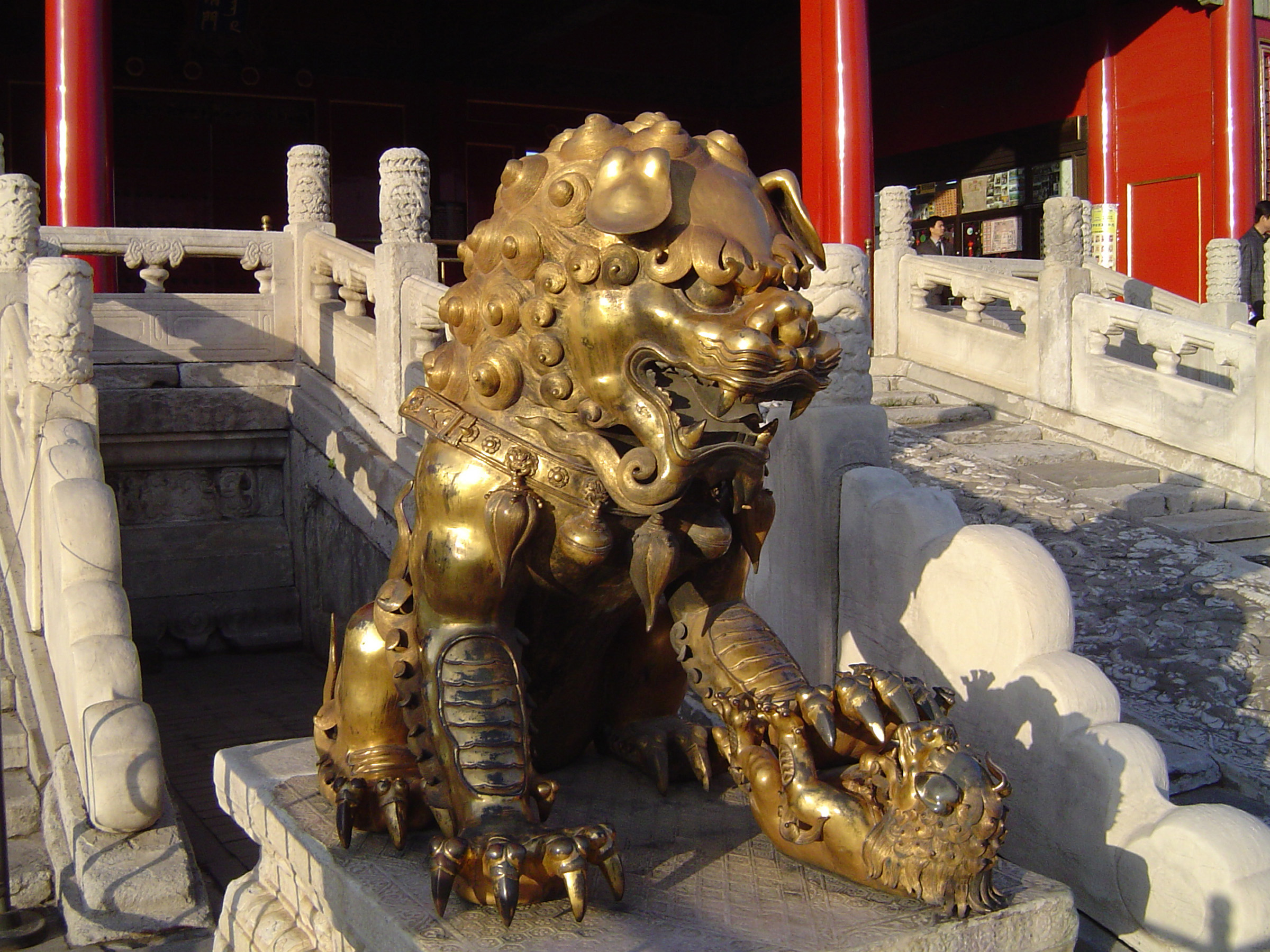 an image of Close up Vintage Golden Qing-era Guardian Lion at Famous Forbidden City in Beijing, China.