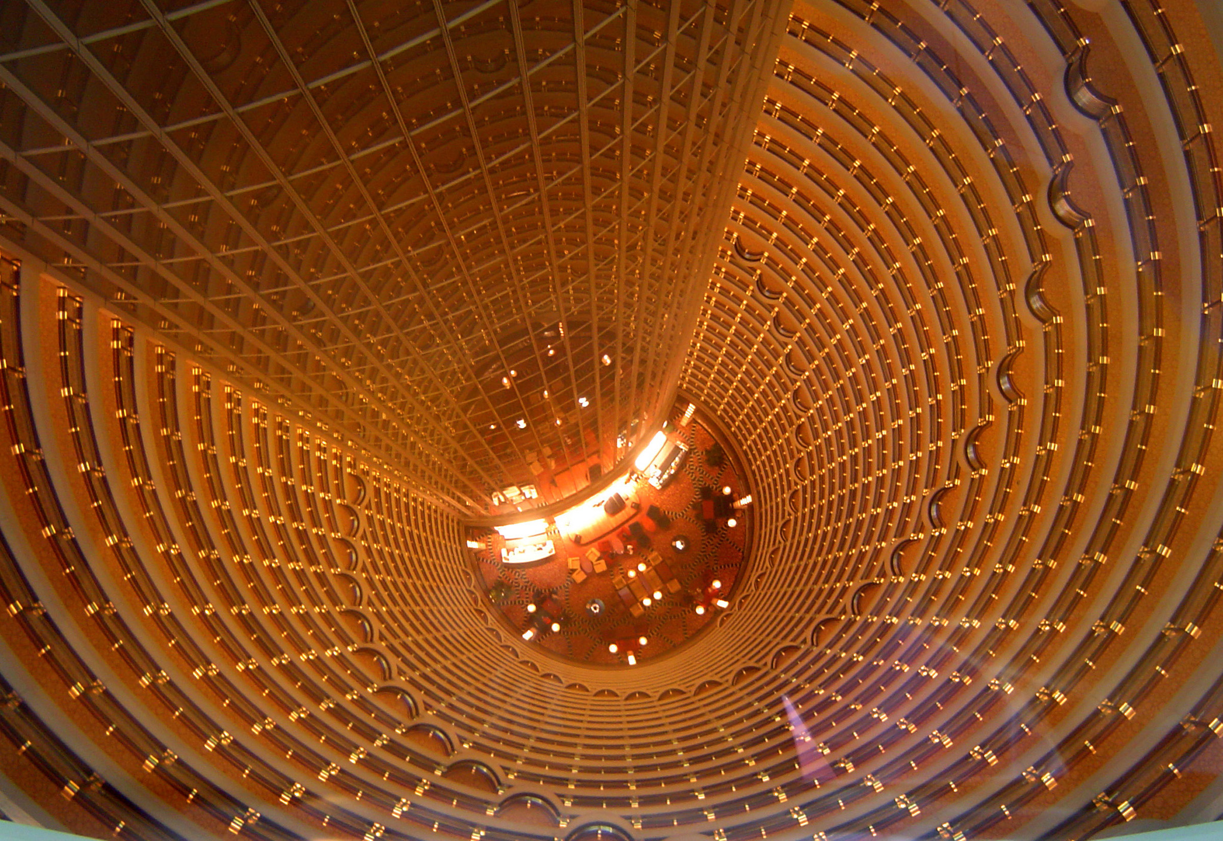 an image of Distant hotel lobby viewed looking down the central open circular well of the building from a dizzy height many storeys up in the air