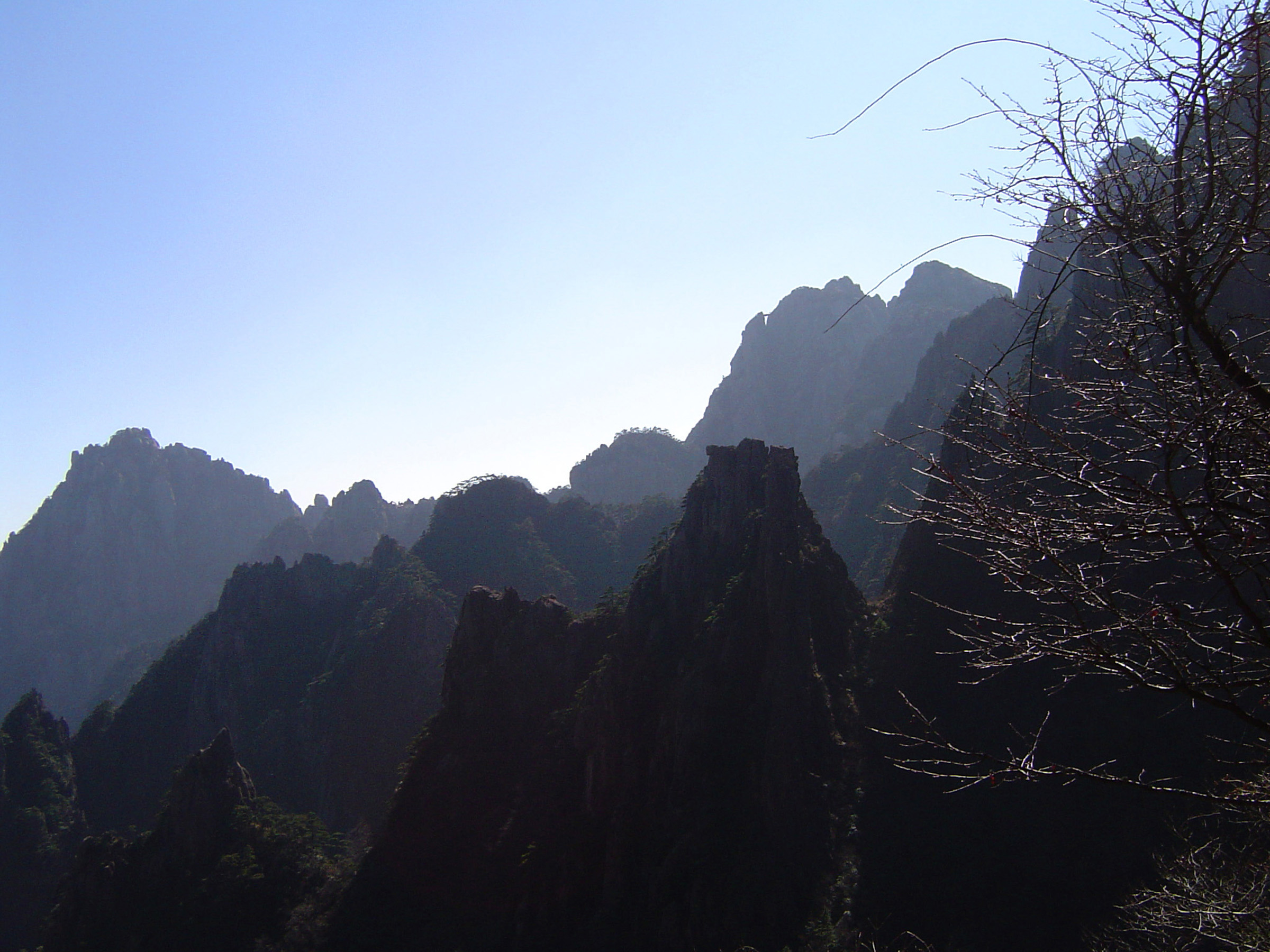 an image of Huge Huangshan Yellow Mountain Range on Light Blue Sky Background at China in Panoramic View.