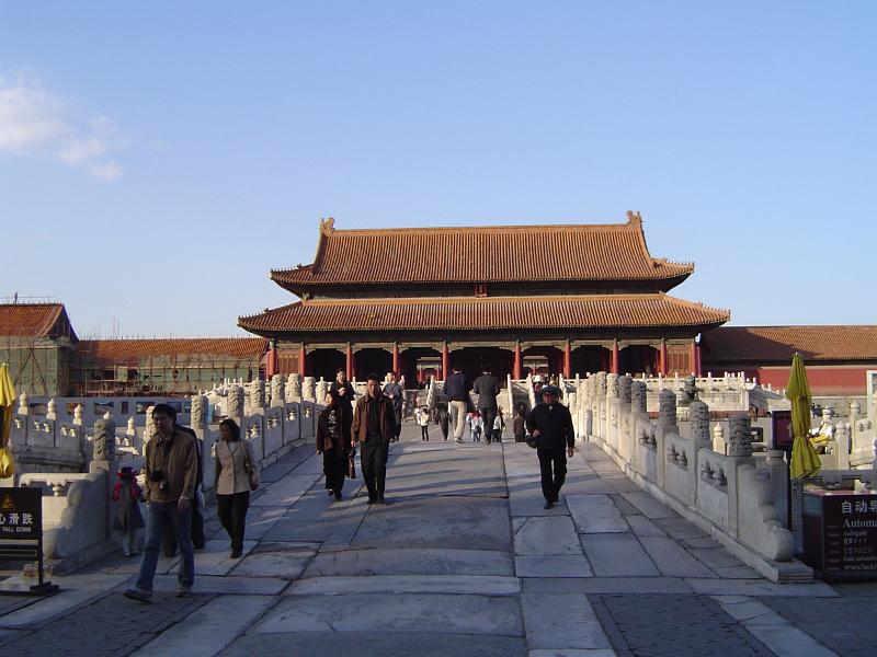 Random Visitors at Famous Chinese Attraction, Forbidden City Temple in Beijing, on Lighter Blue Sky Background.