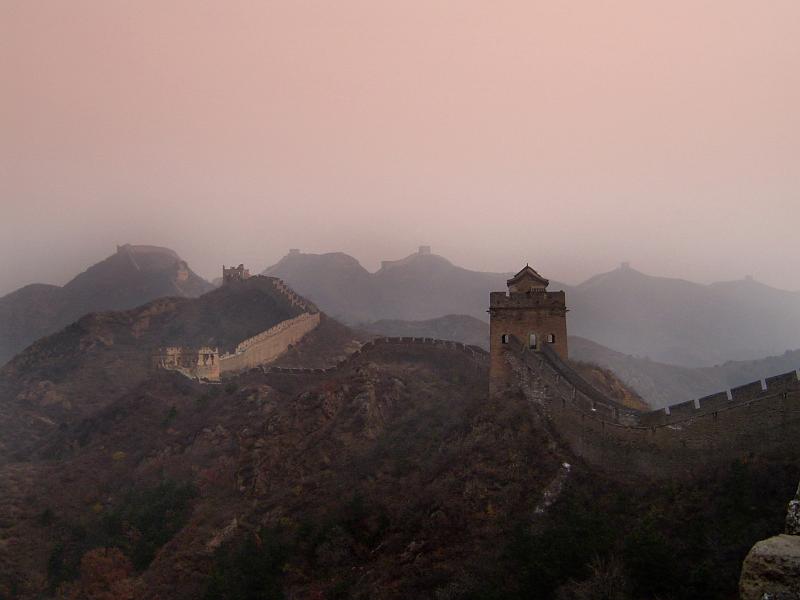 Great Wall of China built to defend the Empire snaking across mountains and valleys on a misty day with smog