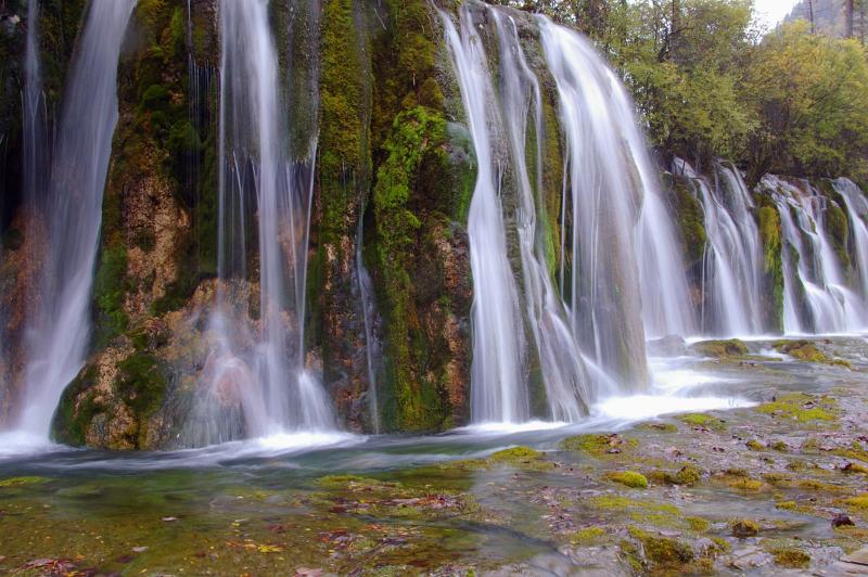 Beautiful Attraction of Natural Waterfalls From High Rocks with Green Plants and Trees Located in China
