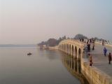 Random Tourists at Famous Architectural Vintage Arch Bridge on Lake in Beijing China
