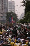 Plenty of Assorted Motorcycles Parked at the City Parking Area Captured with Random Chinese People.