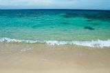 Environmental background of an idyllic sandy beach and clear blue tropical ocean suitable for travel and vacation