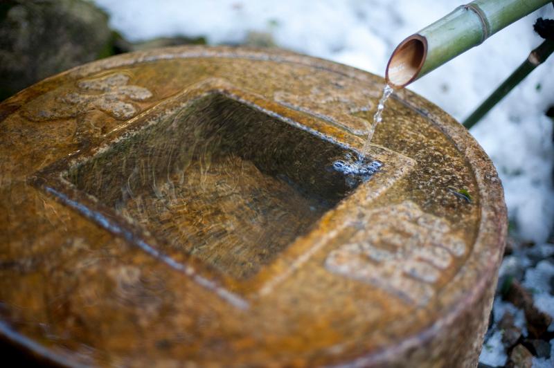 Tsukubai at RyoÂan-ji, it is traditional for Buddhist temples for visitors to purify with the ritual washing of hands and mouth, water running from a tube called a kakei