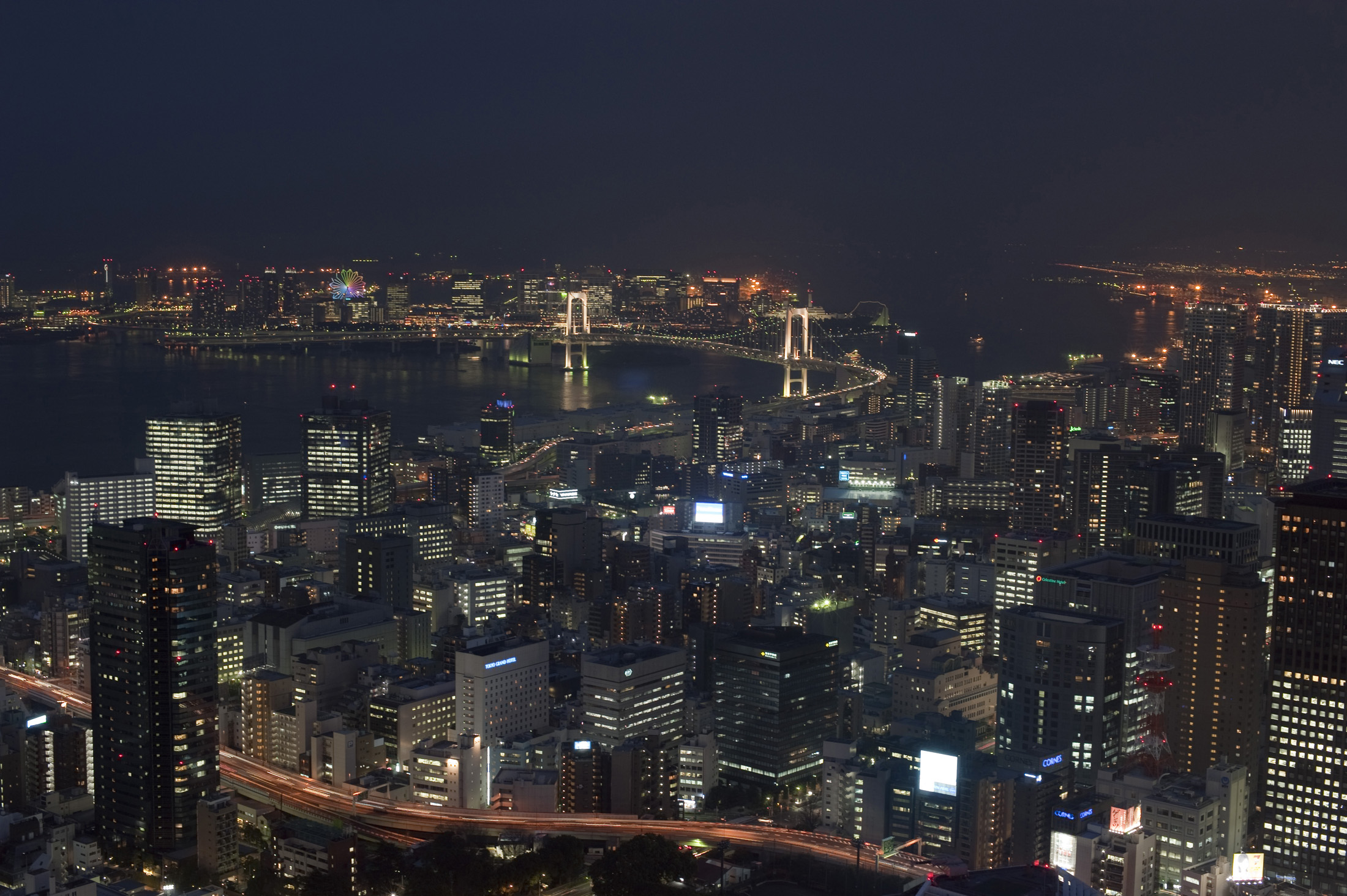 an image of aerial view of tokyo at night featuring the rainbow bridge
