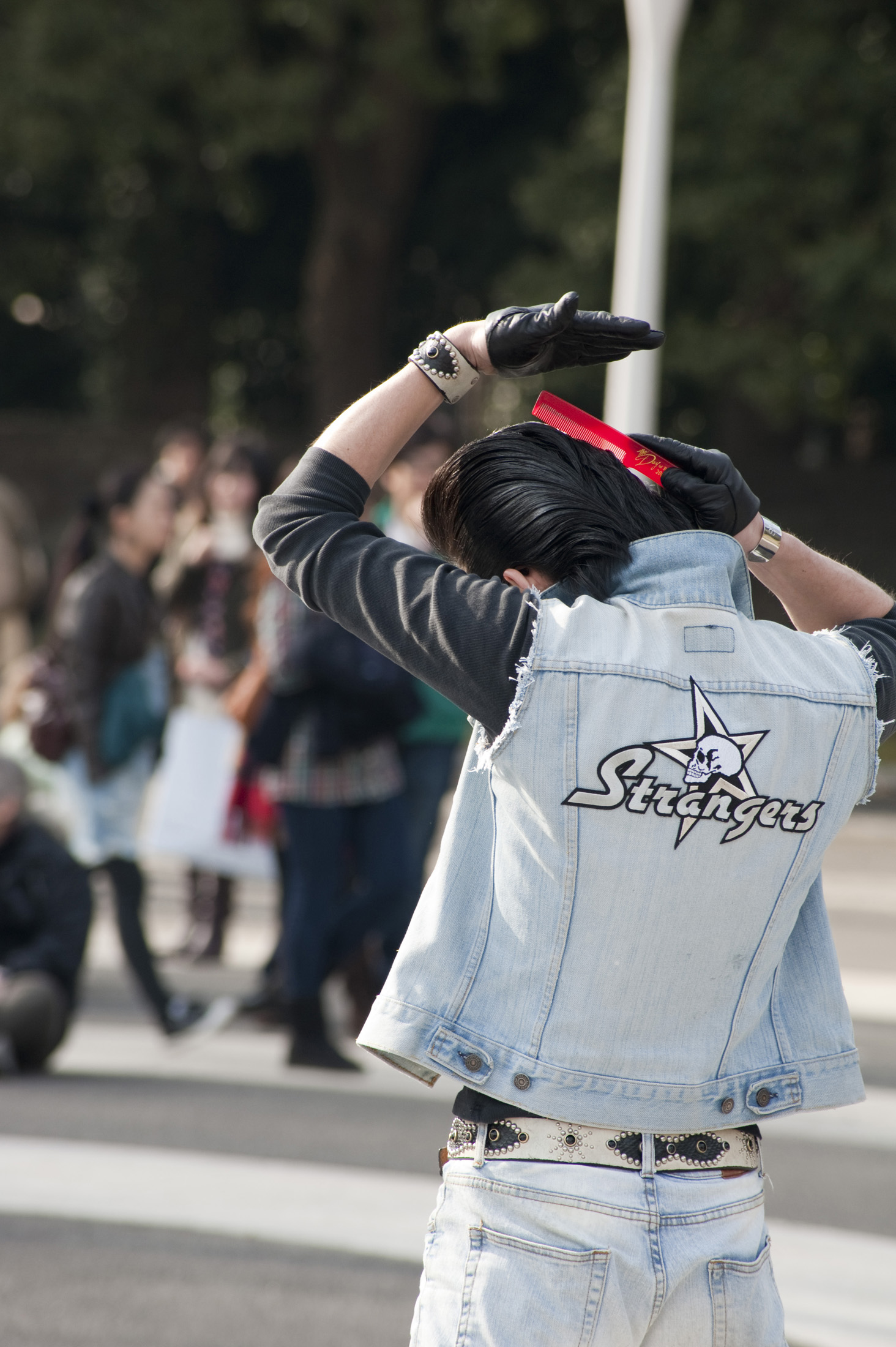 an image of A rocker in Tokyos Yoyogi Park tends his hair - not model released