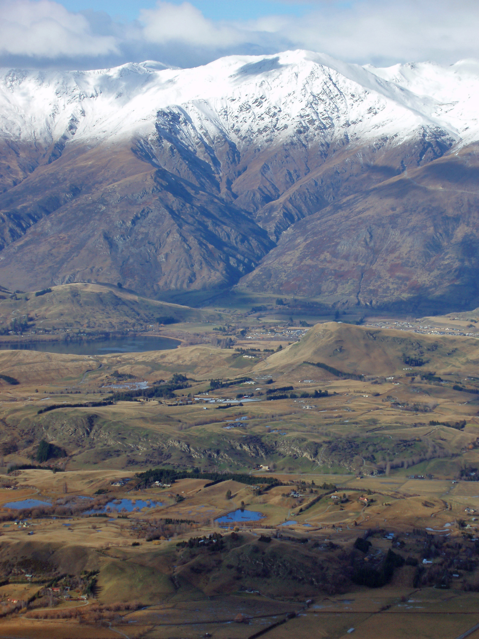 an image of snow covered mountains viewed from coronet peak with a clear snow line below which the snow has melted