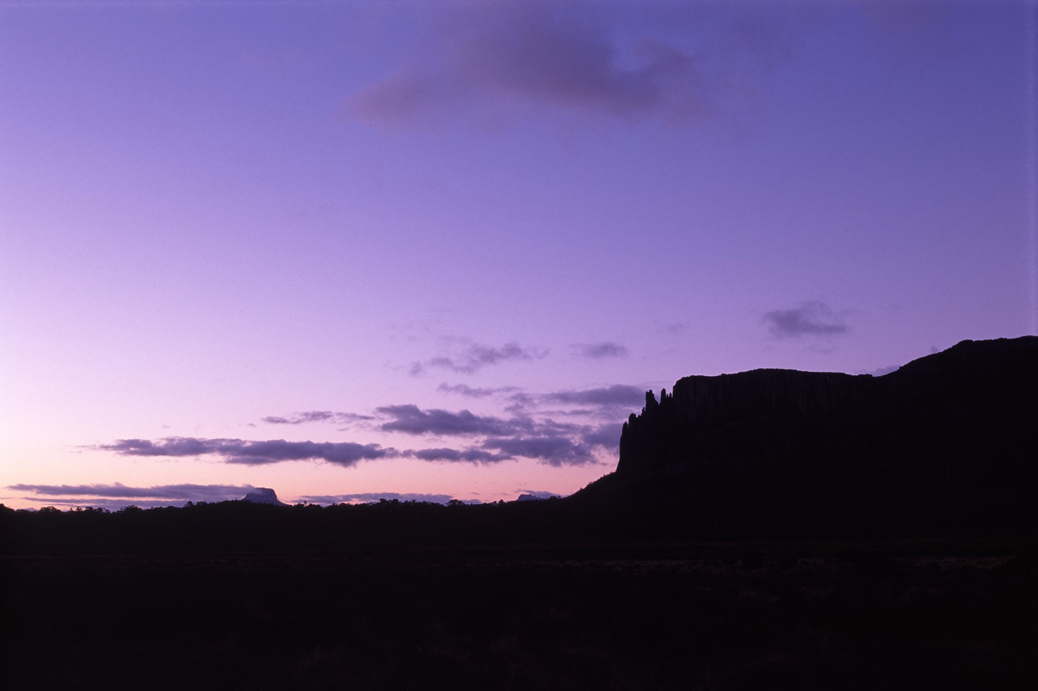 an image of Purple Sunset Over Rocky Silhouetted Tasmania Landscape